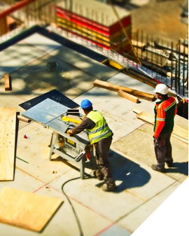 Two construction workers are working on a building.